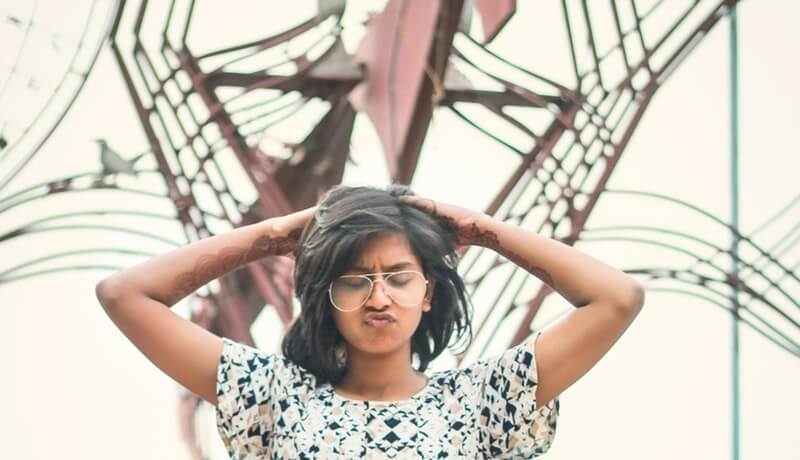 Vrouw die gefrustreerd met haar handen door haar haar gaat